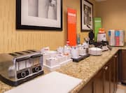 Breakfast Service Area with Toaster, Waffle Iron, and Condiments on Counter