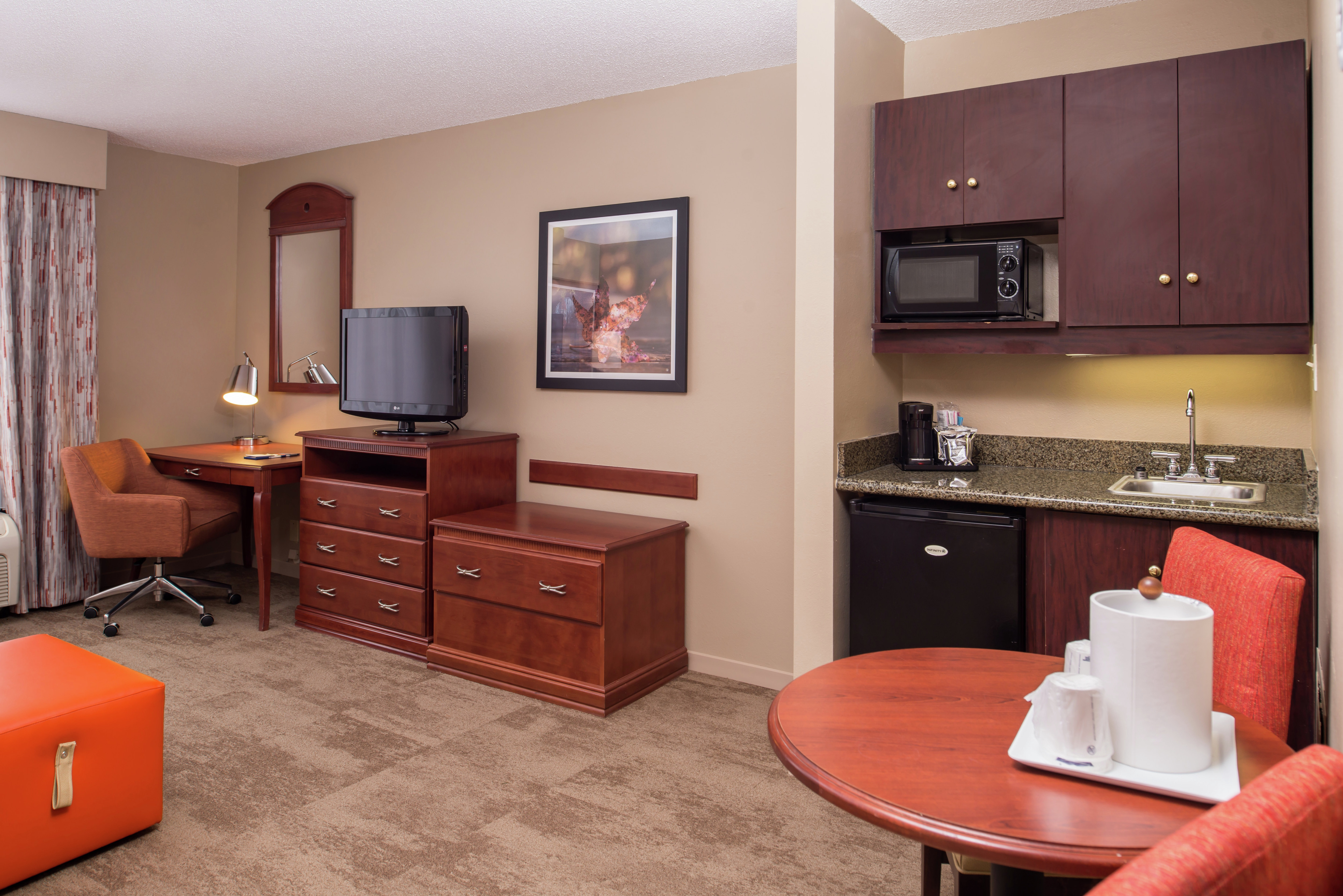 Work Desk, TV, Wet Bar, and Seating for Two at Dining Table in Deluxe Guest Room