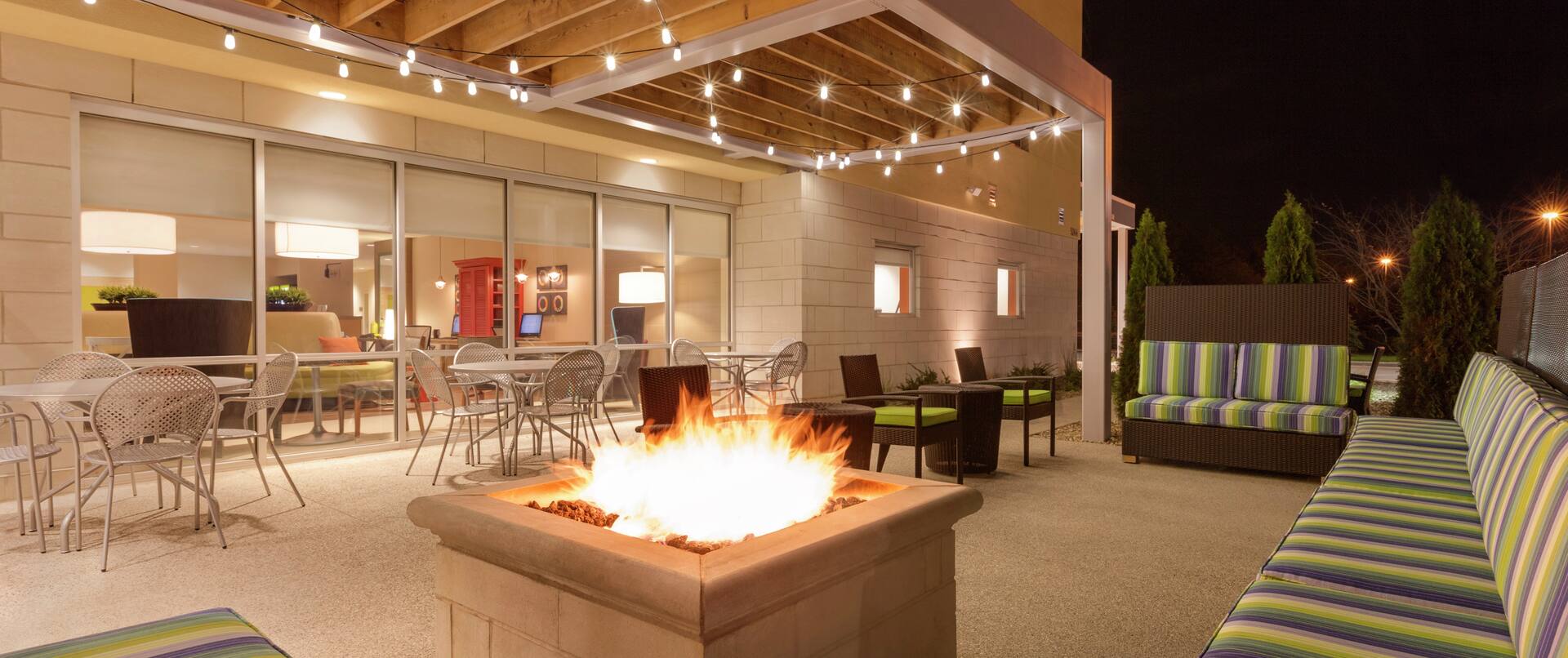 Outdoor Lounge Area with Fire Pit Table at Night