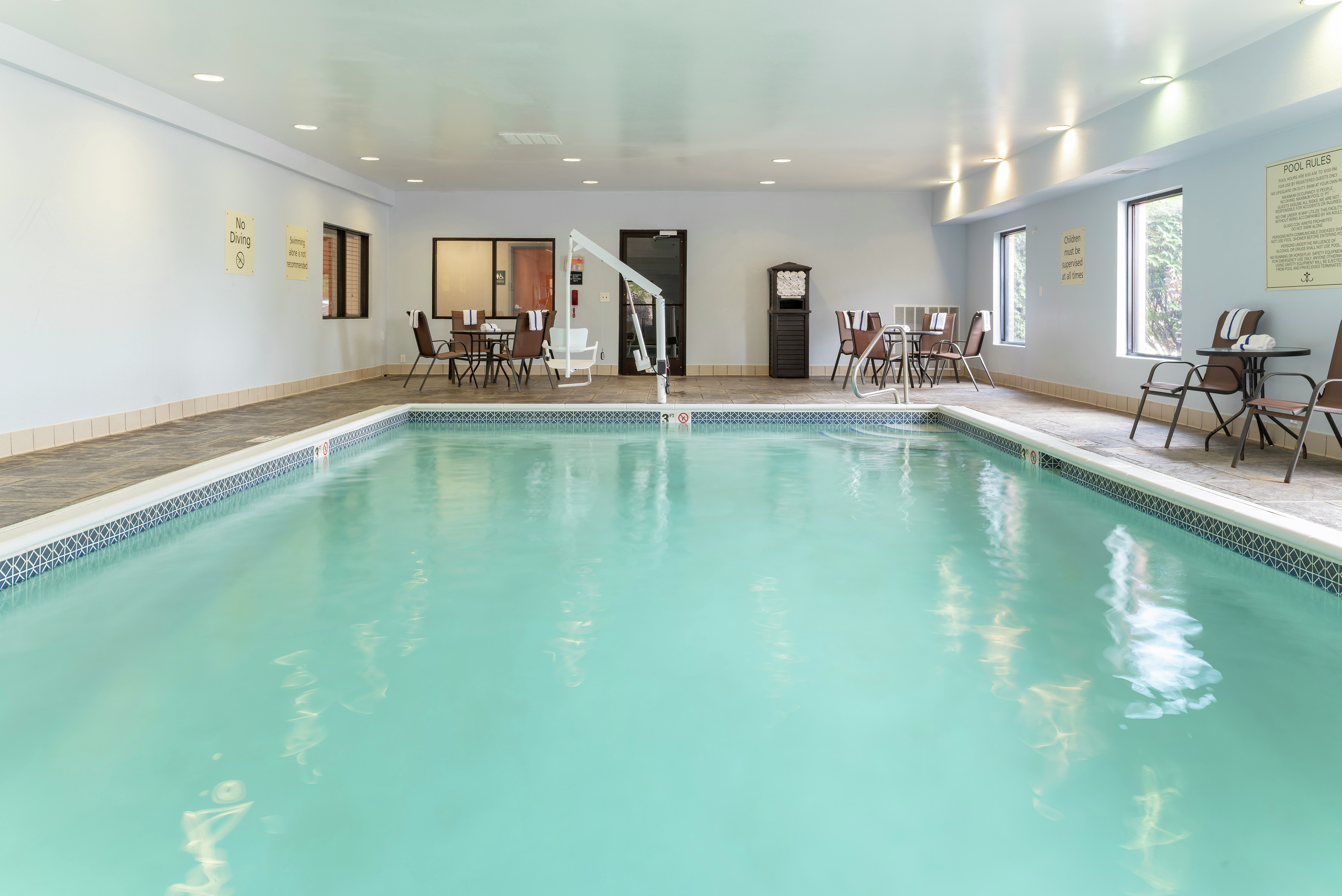 Indoor Pool Area with Tables and Chairs