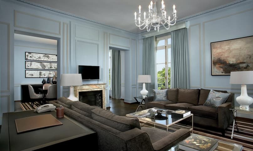 Versailles Suite living area with large comfortable sofas, fireplace and flatscreen TV