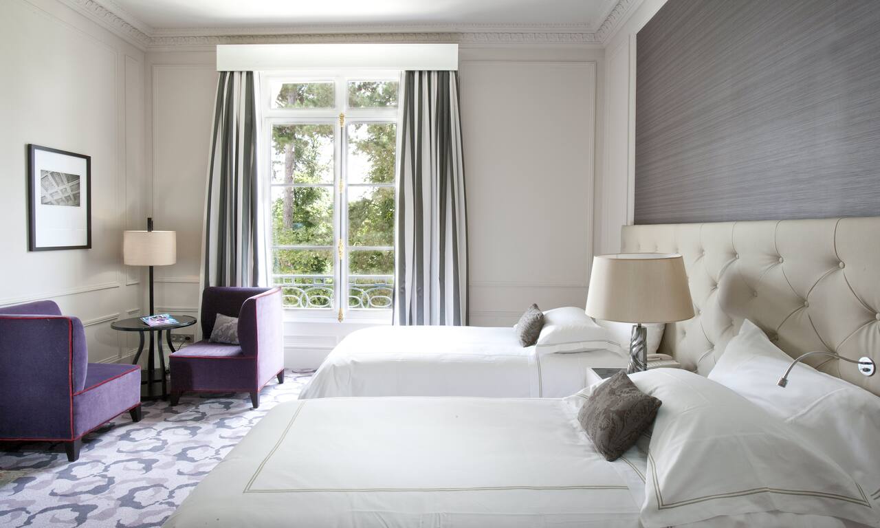 Two Beds in Hotel Room with Seating Area and Garden View