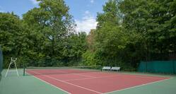 Tennis court with net and trees