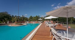 Outdoor Pool Area with Tables and Chairs under Umbrellas