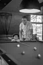 실내 수영장 테이블에서 게임을 하는 아버지와 아들.