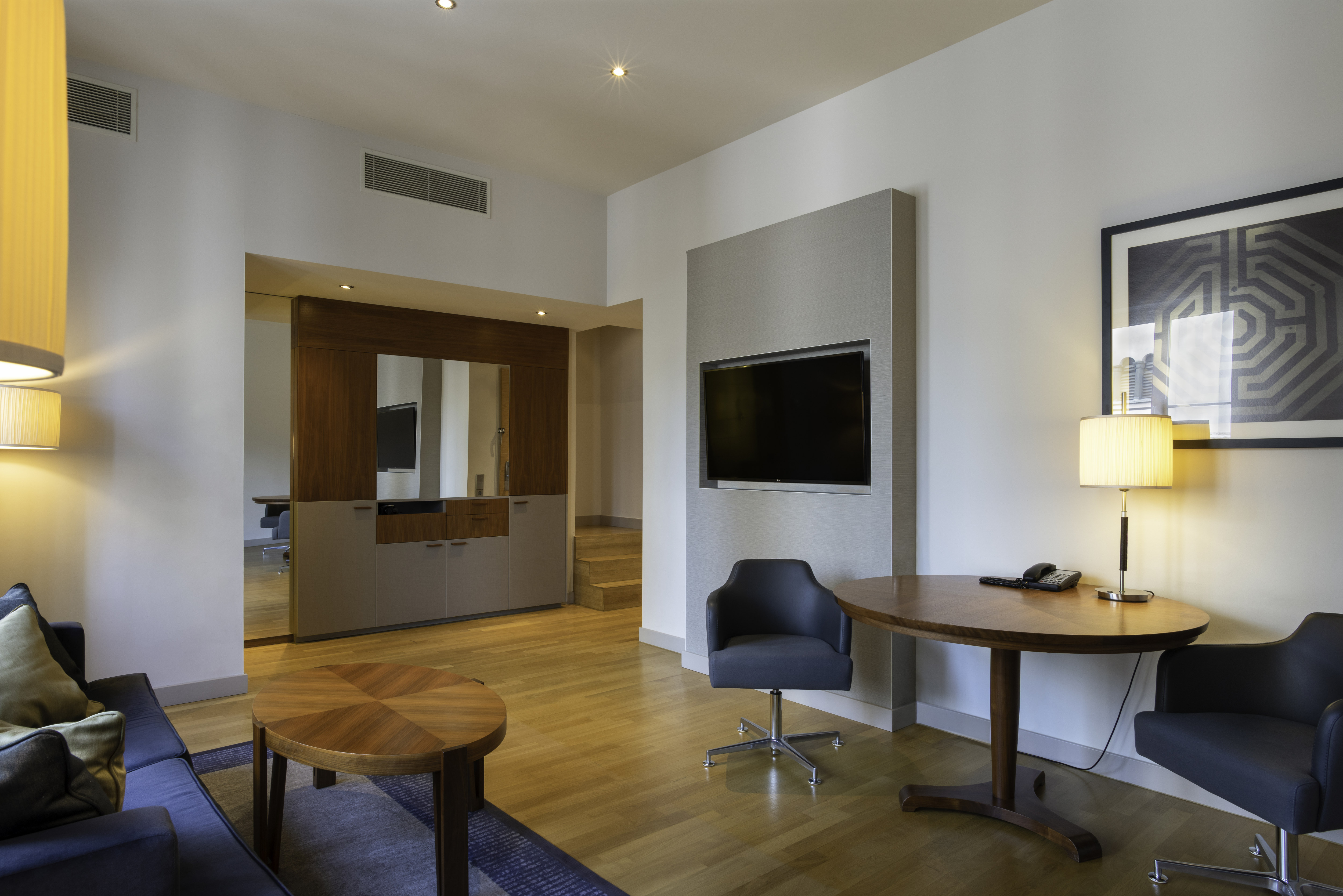 Blick auf den Wohnbereich der Suite mit HD-Fernseher und Schreibtisch