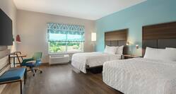 Spacious accessible guest room featuring two comfortable queen beds, work desk, TV, and beautiful outside view.