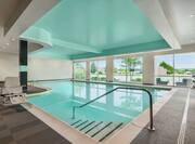 Spacious indoor pool featuring floor to ceiling windows and accessible chair lift.