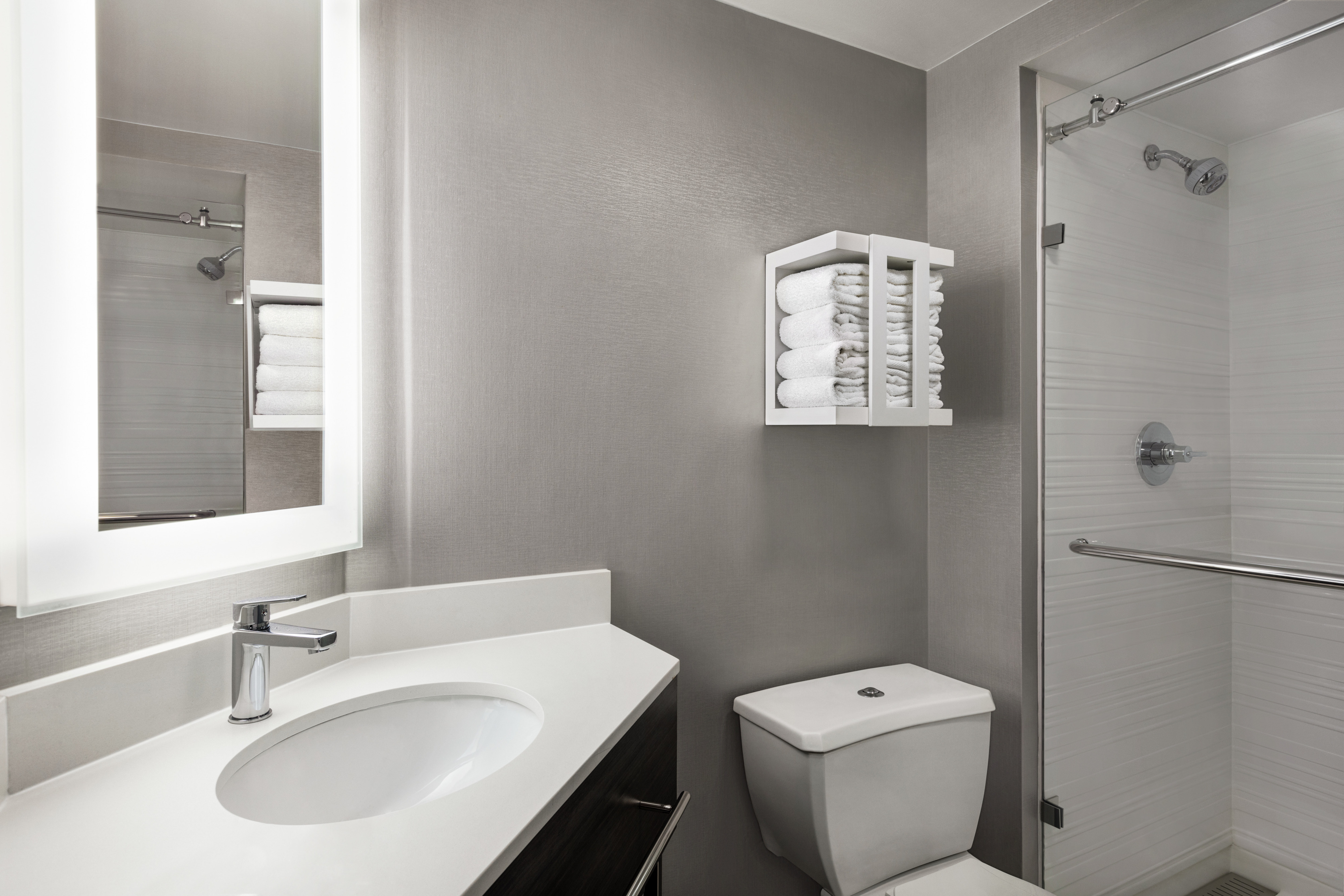 Ample view of vanity, facilities and storage for towels.