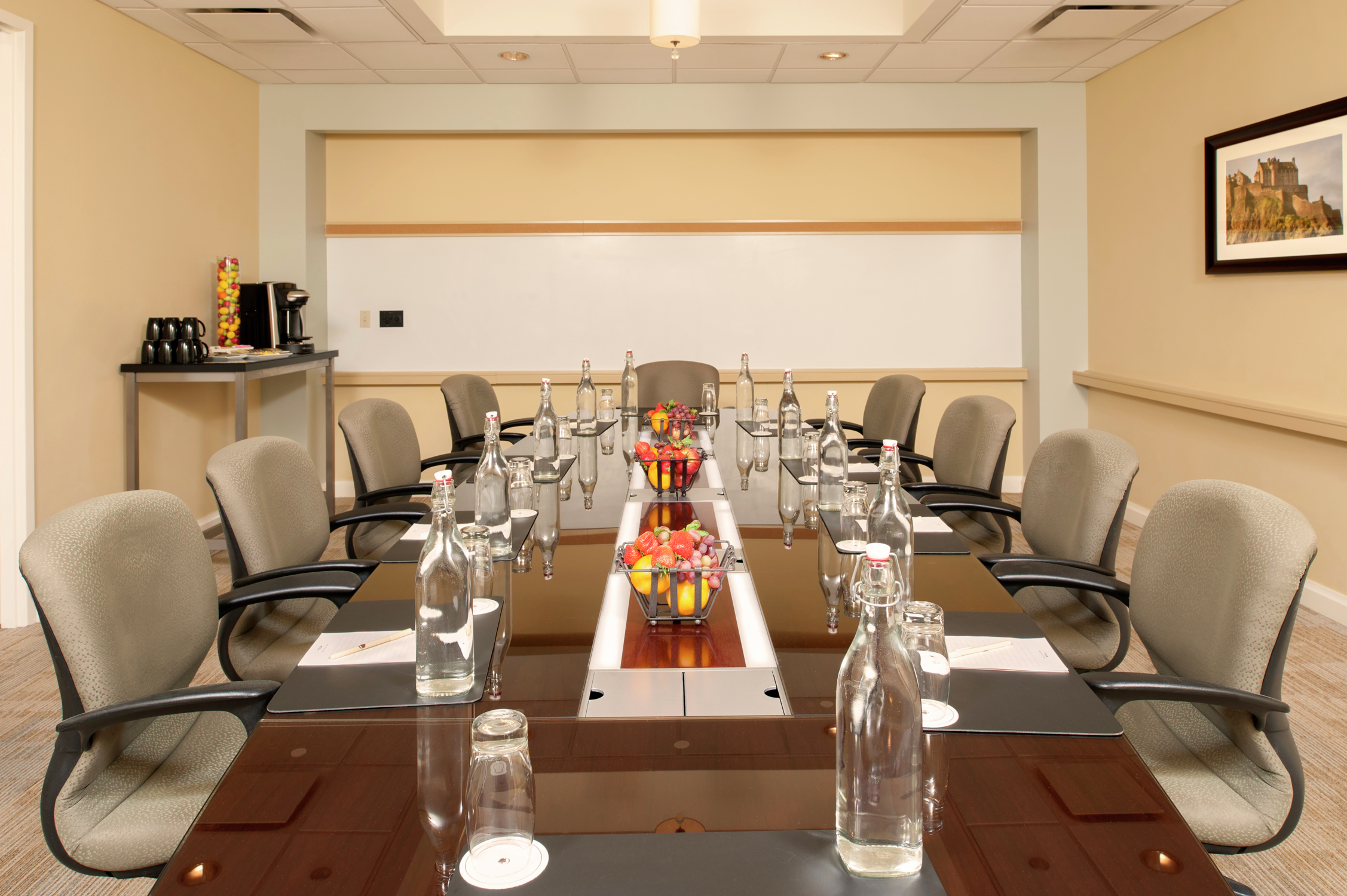 Water Pitchers, Bowls of Fruits, Notepads, and Chairs at Boardroom Table
