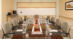 Water Pitchers, Bowls of Fruits, Notepads, and Chairs at Boardroom Table