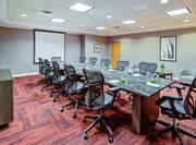 Boardroom with long table, chairs, and presentation screen