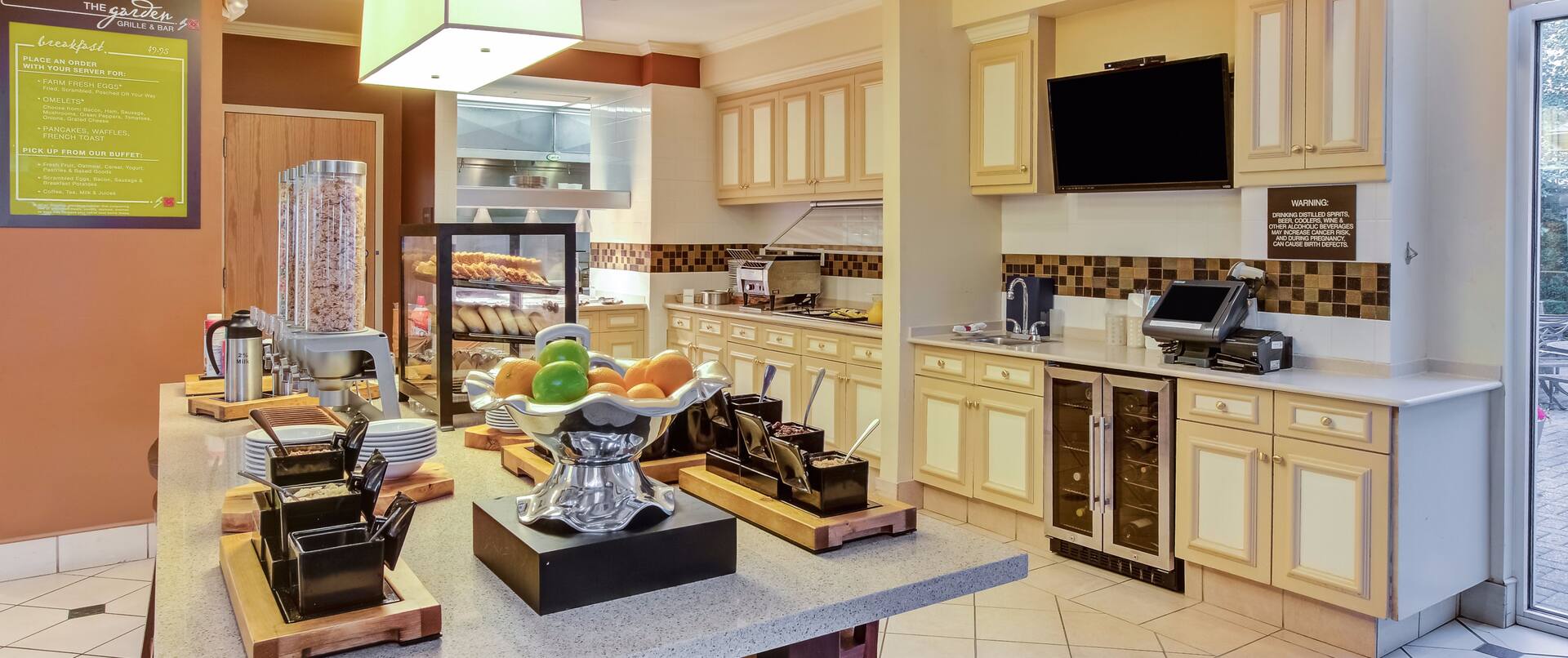Breakfast serving area with cereals, oatmeal, pastries, fruits, and dining amenities