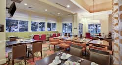 Breakfast dining area with tables, chairs, dining amenities, and windows with outdoor view