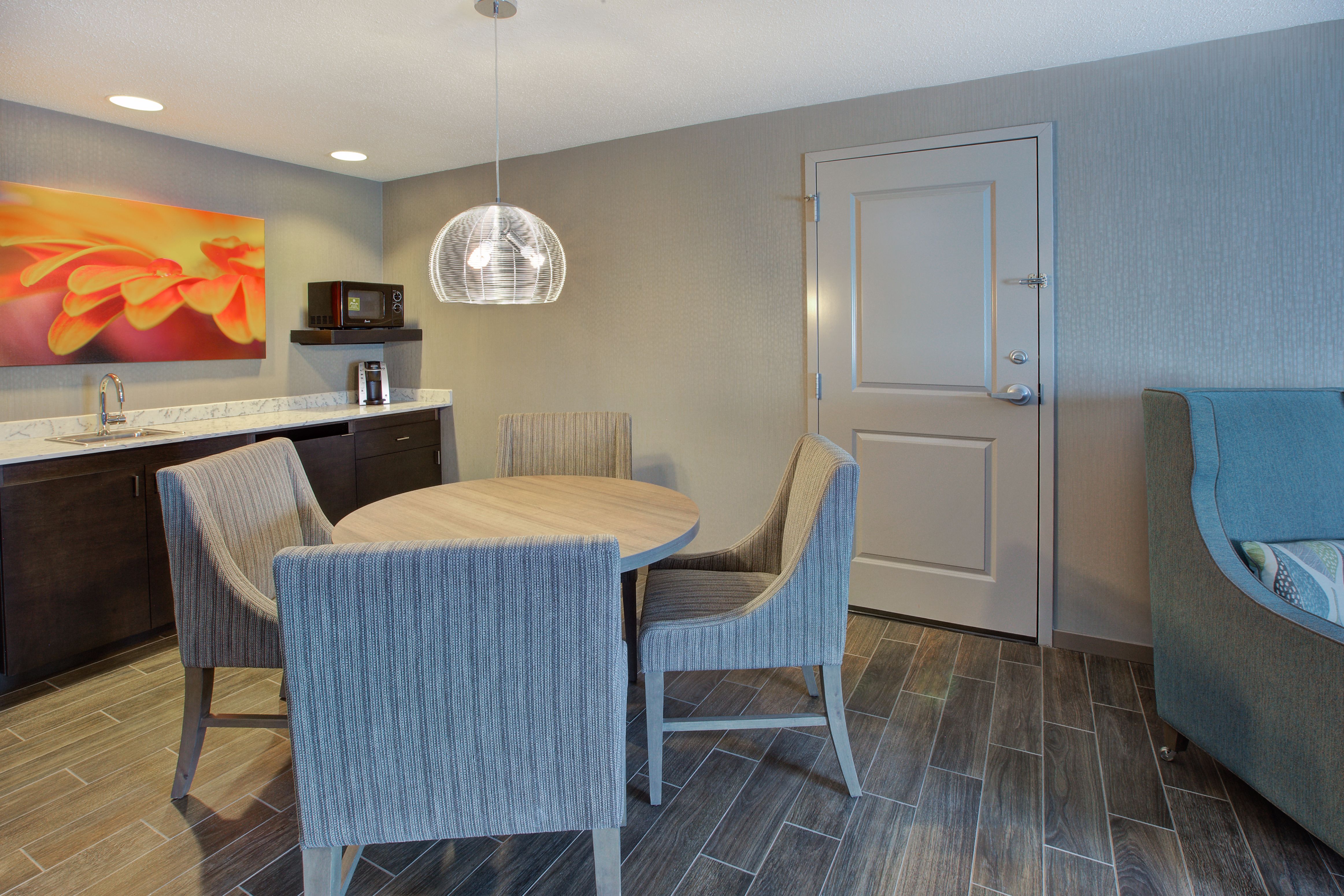 Executive suite dining area with dining table, chairs, microwave, coffee maker, and room entrance