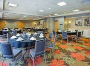 Meeting room with banquet setup, round tables, chairs, and dining amenities