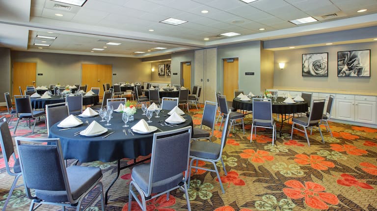 Meeting room with banquet setup, round tables, chairs, and dining amenities