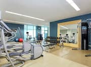 Fitness Center with Blue Walls, Large Windows, Cardio Equipment, Weight Machines and Free Weights