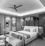 Bed in guest room with blue couch, flowers on table and book