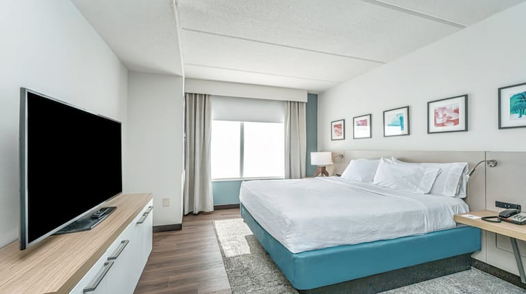 Wide shot of king bed and tv