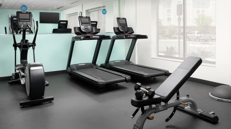 Fitness center with cardio machines and weight bench
