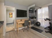 Desk HDTV and Exercise Equipment in Fitness Suite