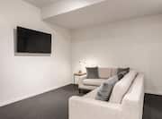 Living room area with sofa and wall mounted TV