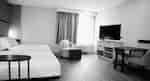 Accessible suite with two queen beds, a chair and ottoman, plus a large window.