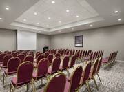 Large conference room with theater setup, podium, and projector screen.