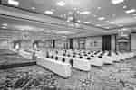 Spacious grand ballroom fully set in classroom style with long tables and ample seating.