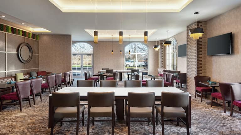 Spacious hotel restaurant featuring ample seating, stylish design, and beautiful outside view.