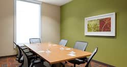 Meeting Room  with Window, Long Table, Seating for Six,  and Colorful Art on Green Wall
