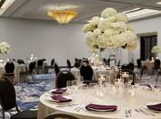 Single Cloth-covered Ballroom Table with Chairs, Flower Centerpiece, More Tables in the Background