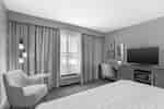 Zimmer mit Kingsize-Bett, Loungesessel, Schreibtisch und Fernseher