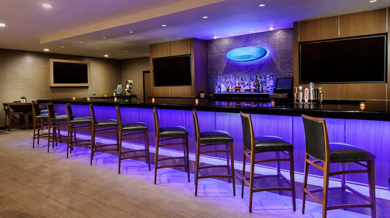 Bar area with stools and TVs