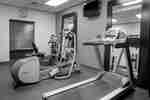 Fitnesscenter mit Laufband, Crosstrainer, Fahrradtrainer und Wandfernseher