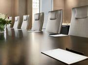 Close-Up of Boardroom Meeting Table with Notepads and Office Chairs