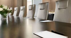 Close-Up of Boardroom Meeting Table with Notepads and Office Chairs