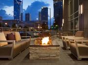 Outdoor Patio Seating Area with Sofa, Firepit and Armchairs at Night