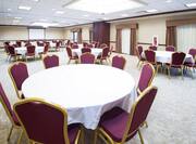 Meeting Room with Chairs and Round Tables Arranged in Banquet Style Setup