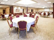Meeting Room with Chairs and Round Tables Arranged in Banquet Style Setup