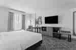 Barrierefreies Schlafzimmer mit Waschbecken, Fernseher und Schreibtisch
