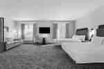 suite with lounge area and double queen beds and tv