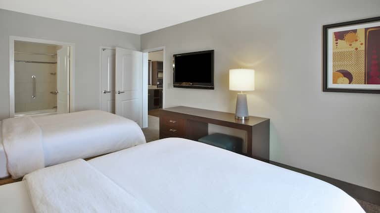 Two Queen Beds, View Into Bathroom, View Into Living Room and TV in Suite Bedroom