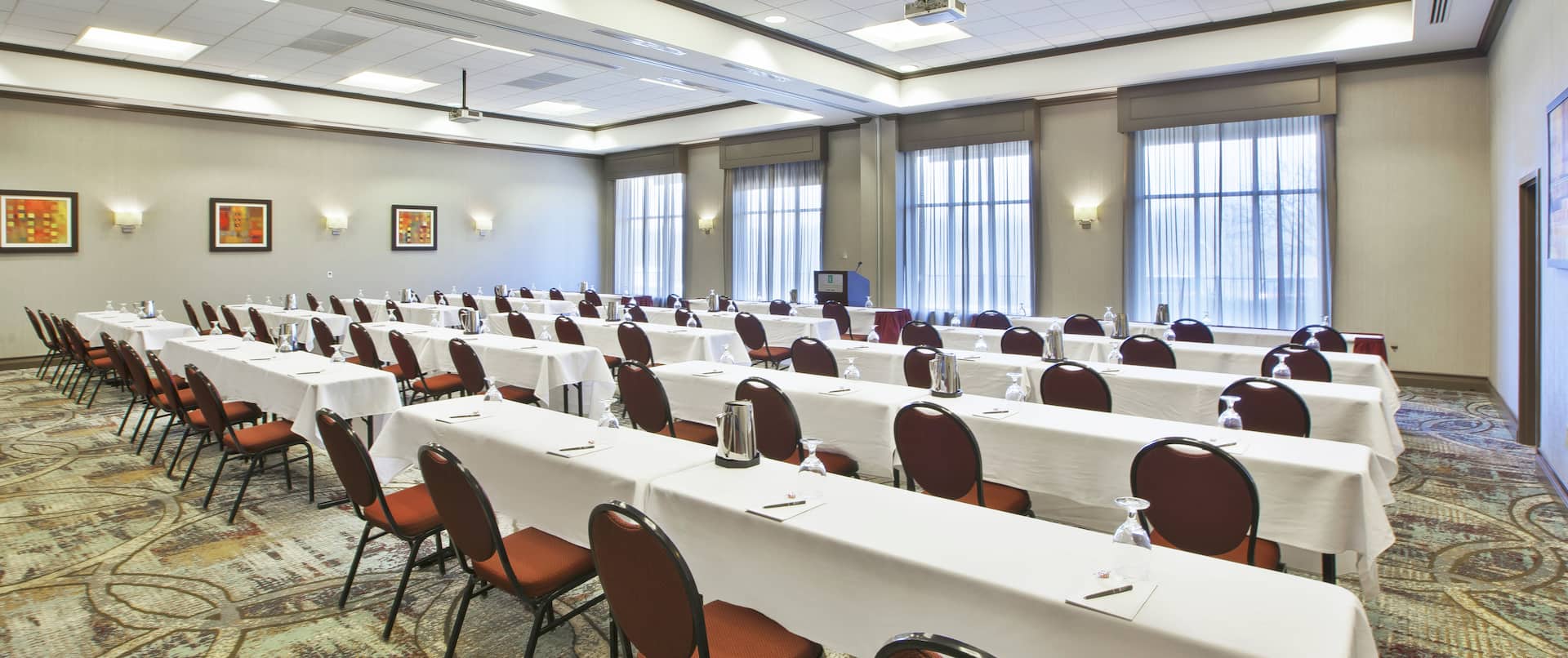 Classroom Setup in Bexley Meeting Room WIth Overhead Projectors, Tables, Chair, Podium, and Windows With Sheer Drapes