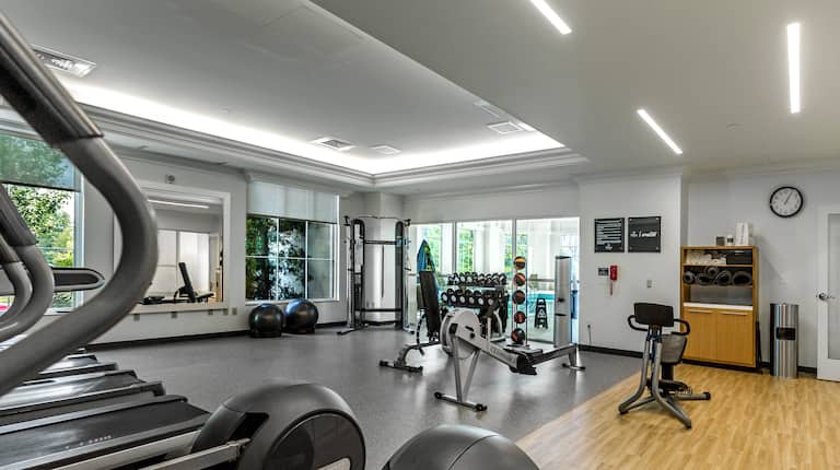 Fitness center with exercise machines, free weights, exercise balls, and windows with outdoor view