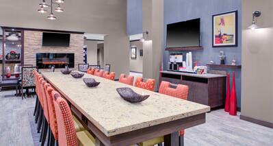 Dining Area with Chairs, Table, Coffee Station, Two Wall Mounted HDTVs and Fireplace
