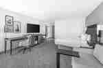 Chambre avec lit confortable, espace salon et bureau de travail