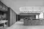 A breakfast buffet area with marble service counters, food displays, cereal dispensers, and a chandelier.