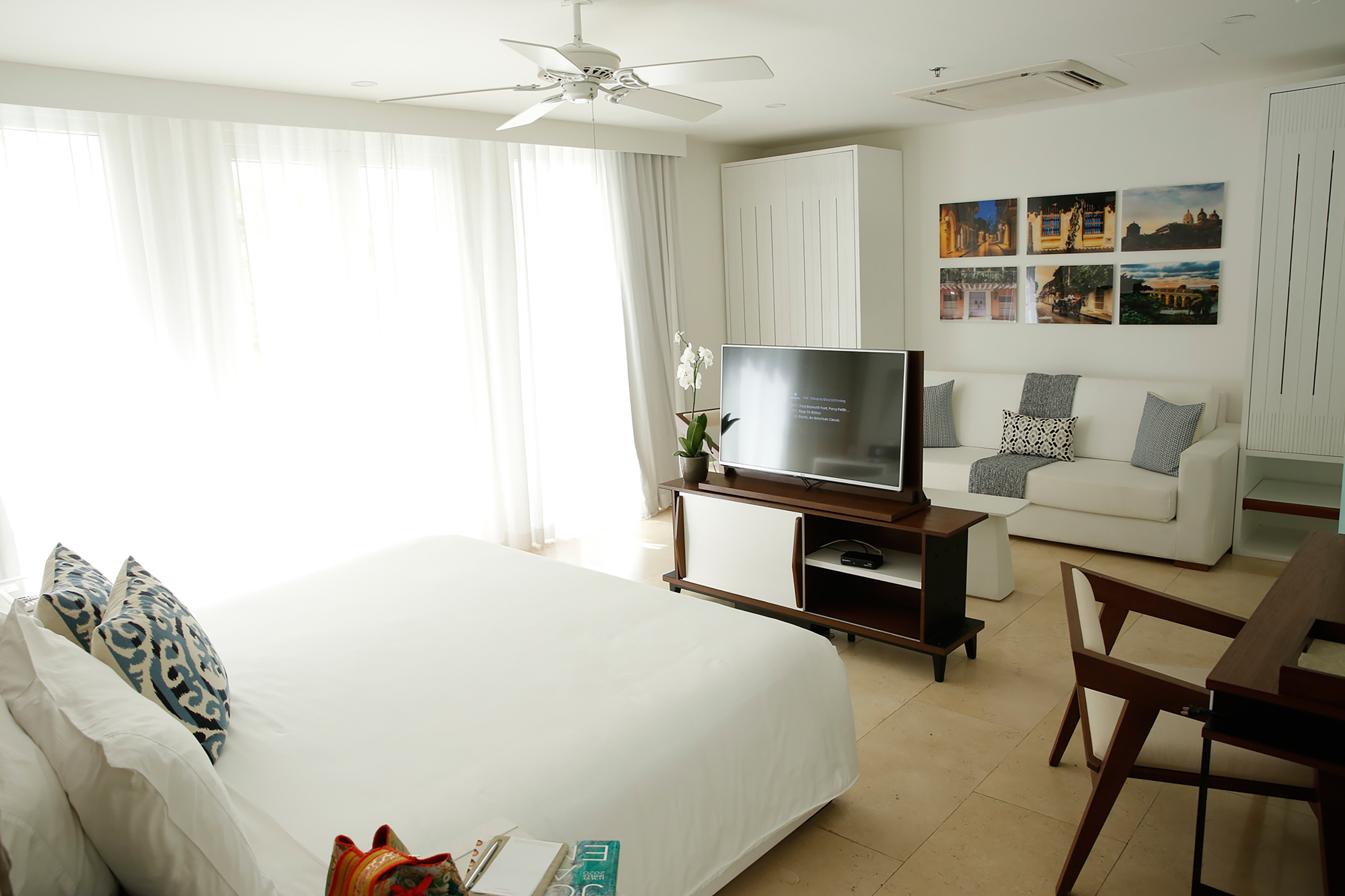 Vista de la cama, el escritorio y el área de lounge de la suite Junior con cama King
